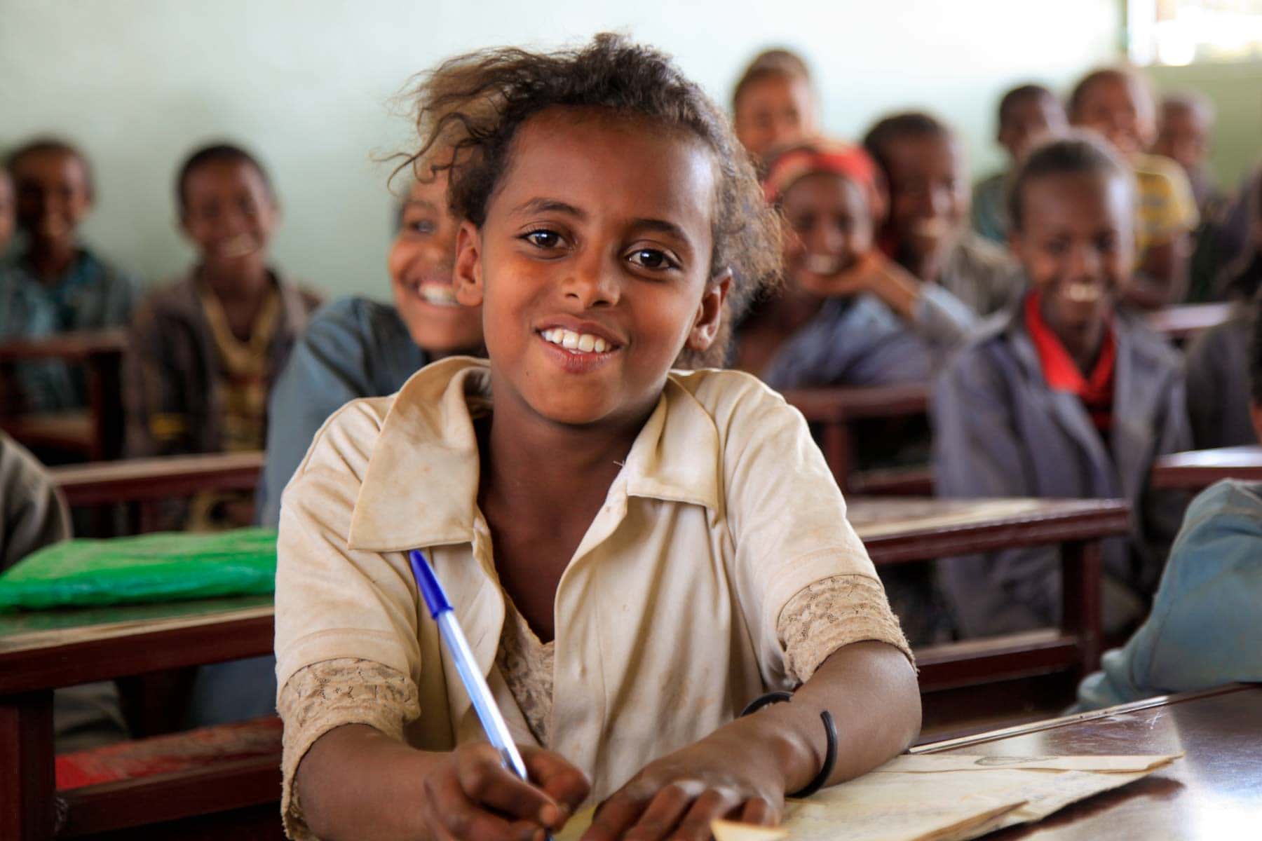 Mädchen sitzen in dunkler Schule in Äthiopien und lächeln